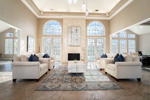A clubroom with a fireplace and a rug in front of it.