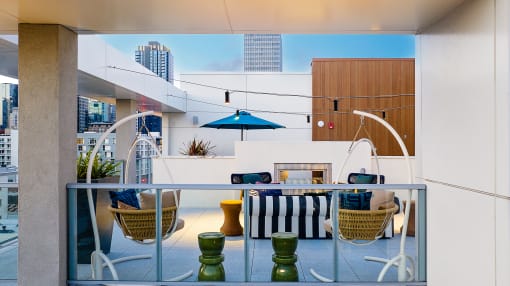 a balcony with a table and chairs and a fireplace with a blue sky in the background