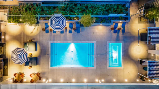 Pet-Friendly Apartments in South Park Los Angeles, CA - The Emerald - Aerial View of Pool, with Blue Lounge Chairs and Cabanas