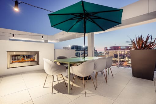 a terrace with a table and chairs and a fireplace