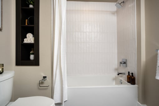 a bathroom with a white tub and a white toilet