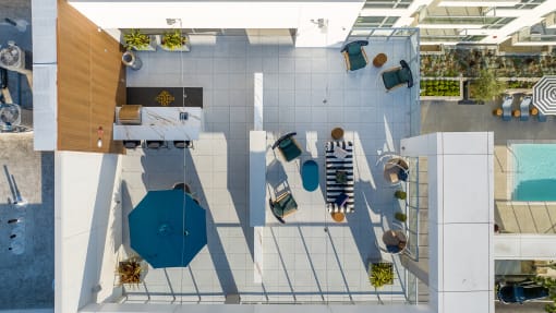 a birdseye view of a patio area with tables and umbrellas and a pool