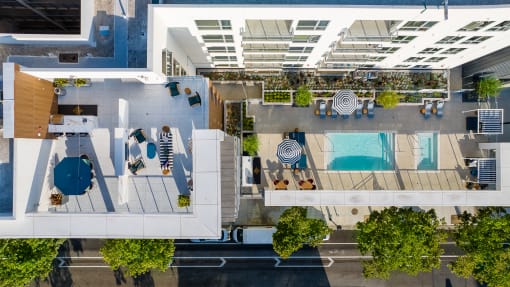 an overhead view of a building with a pool and trees