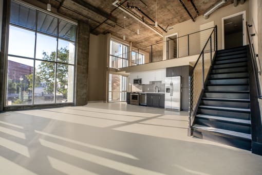 a large open space with a staircase and a kitchen