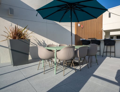 a terrace with a table and chairs and an umbrella