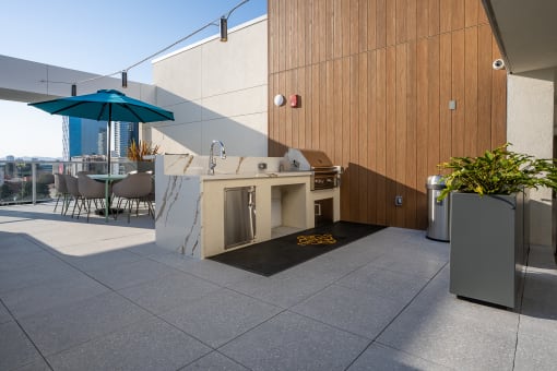 an outdoor kitchen and dining area on the roof of a building