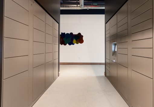 a row of lockers in a room with a colorful painting on the wall