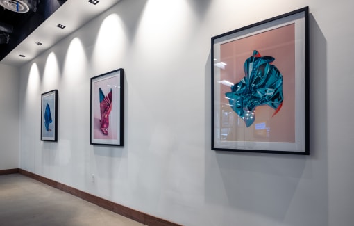 a row of framed artwork on a white wall