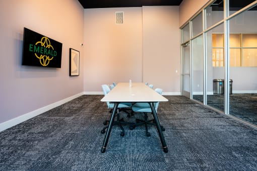 a meeting room with a white table and chairs