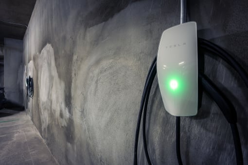 a power adapter plugged into a wall with a green light shining on it
