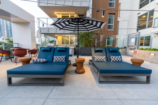 a seating area with blue couches and a black and white umbrella