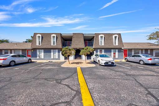 A parking lot with cars and a building in the background.