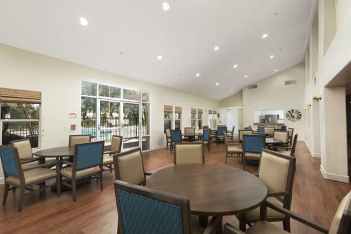 Clubhouse Lounge sitting area with a couch, three chairs, coffee table, large rug and decor at 55+ FountainGlen Rancho Santa Margarita, California, 92688