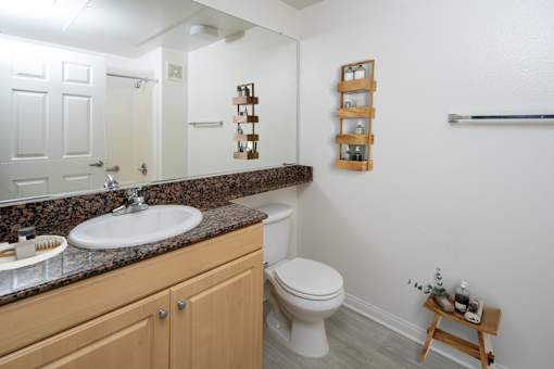 Small bathroom with brown cabinet at 55+ FountainGlen Grand Isle, California