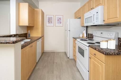 Modern kitchen with wooden cabinets setup at 55+ FountainGlen Grand Isle, California, 92562