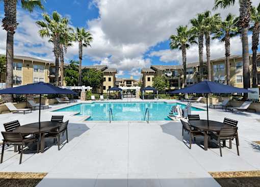 Pool area with tables and umbrellas at 55+ FountainGlen Temecula, Temecula, CA, 92591