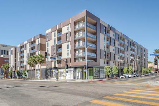 A modern apartment building with a street view in front at Wilshire Valencia Apartment, Los Angeles, CA, 90017