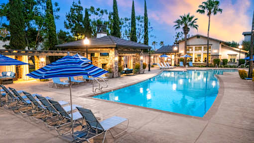 Poolside area with lounge chairs at The Grove Apartments, Ontario, 91761