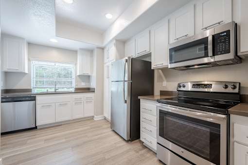 A kitchen with white cabinets and stainless steel appliances.