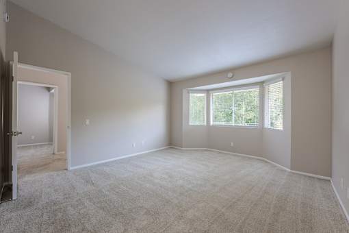 A large empty room with a door and a window.