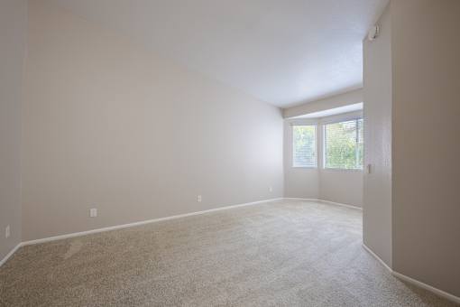 A room with a carpeted floor and a door leading to a balcony.