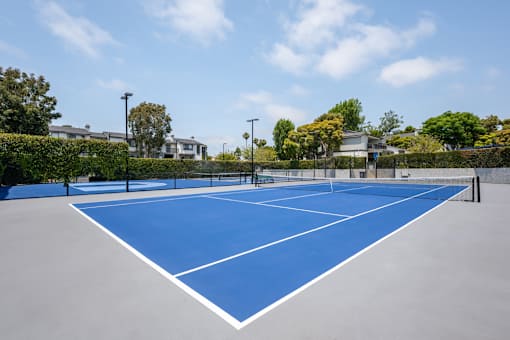 A tennis court with a blue surface and white lines.