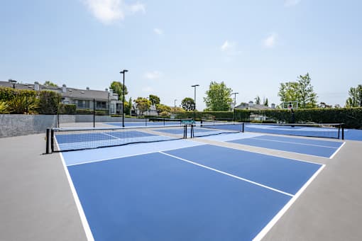 A tennis court with blue surface and white lines.