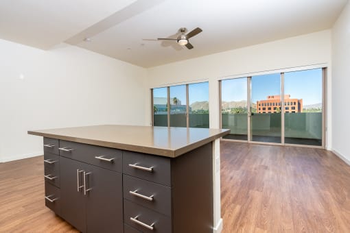 kitchen island and  livingroom with wood style floor and large windows at Imperial Hardware Lofts, Riverside, CA