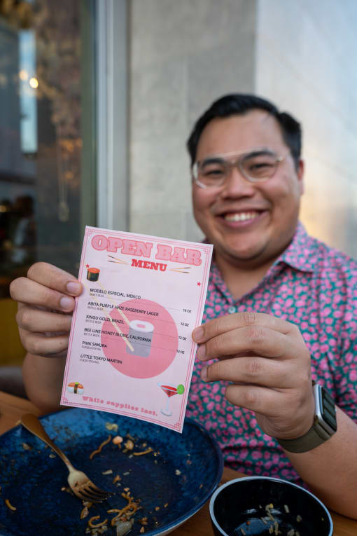 Man holding pink menu card. at Imperial Hardware Lofts, California