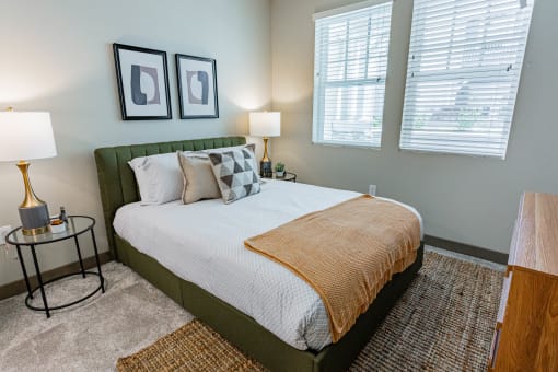 Apartments For Rent Burlingame, CA - Bedroom With Bed, Carpet Flooring, Two Nightstands With Lamps, Modern Decor, Dresser, And Two Windows.