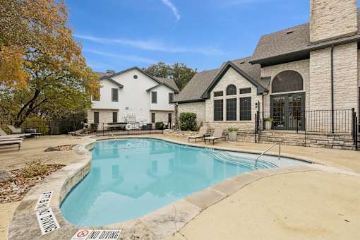A pool surrounded by a black fence with a sign that says "No Diving".