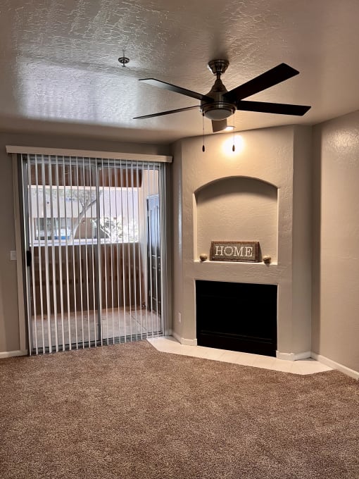 a living room with a fireplace and a ceiling fan