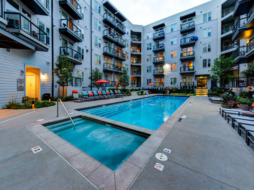Resort-Inspired Pool With Lounge Chairs, Umbrellas, Spa, And Maintained Landscaping at Waterford RiNo, Denver