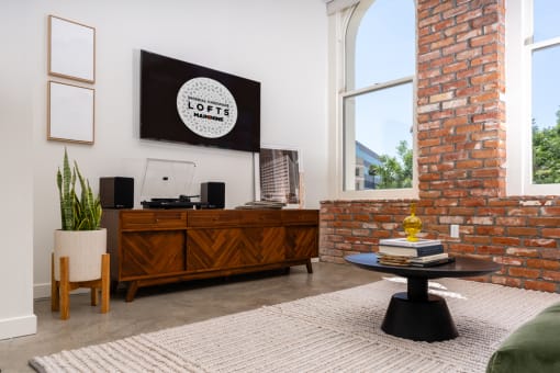 a living room with a brick wall and a large window at Imperial Hardware Lofts, Riverside