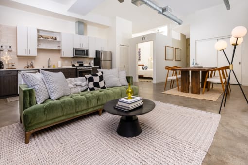 a living room with a green couch and a table at Imperial Hardware Lofts, Riverside, CA, 92501