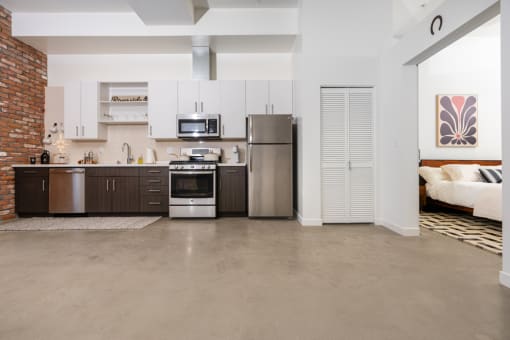 a kitchen with stainless steel appliances and white cabinets at Imperial Hardware Lofts, California, 92501