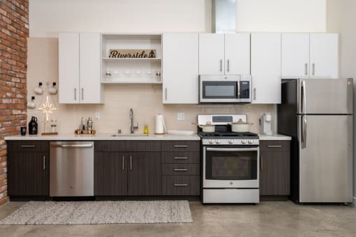 a kitchen with white cabinets and stainless steel appliances at Imperial Hardware Lofts, Riverside, CA, 92501