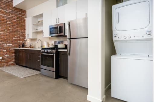 a kitchen with a washer and dryer and a refrigerator at Imperial Hardware Lofts, Riverside, CA, 92501