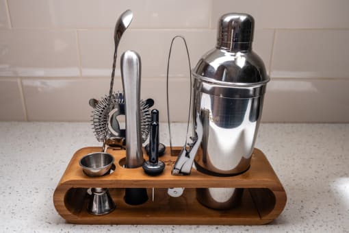 a wooden cutting board with various kitchen utensils on a kitchen counter at Imperial Hardware Lofts, Riverside, CA, 92501