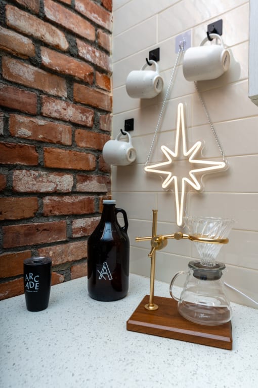 a christmas ornament hanging from a brick wall next to a table with a candle at Imperial Hardware Lofts, California, 92501