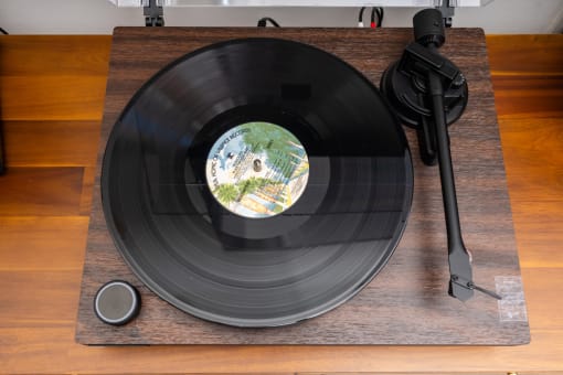 a record on a wooden table with a record player and a vinyl record on it at Imperial Hardware Lofts, Riverside