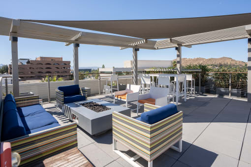 a rooftop patio with couches and chairs and a fire pit at Imperial Hardware Lofts, Riverside, CA