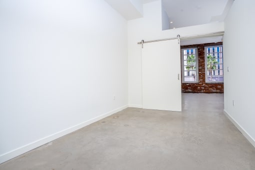 room with white walls and barn style sliding door at Imperial Hardware Lofts, California, 92501