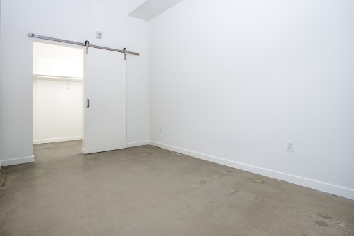 room with barn sliding door and white walls at Imperial Hardware Lofts, Riverside