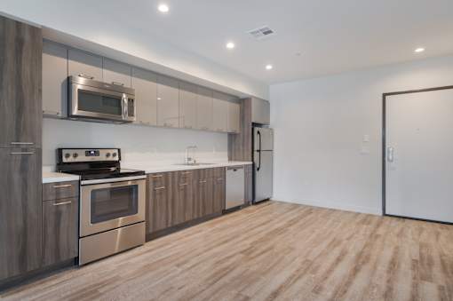 A modern kitchen with wooden cabinets and stainless steel appliances at Wilshire Valencia Apartment, California, 90017