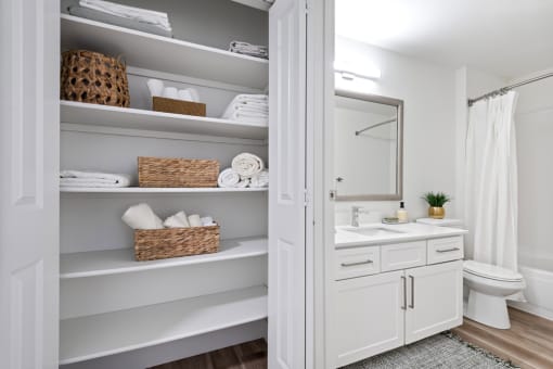 a white bathroom with open shelving and a white toilet and sink at Lakemont Orchard, Issaquah Washington  