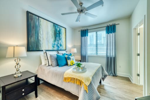 Studio, One, & Two-Bedroom Luxury Apartments In Phoenix, AZ - Level At Sixteenth - Bedroom With Spacious Bedroom, Glass Nightstand, And Yellow Decorative Bedding