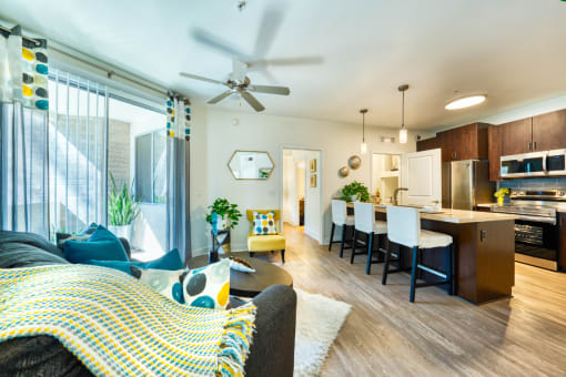 Luxury Apartments For Rent In Phoenix - Level At Sixteenth - Living Room with Ceiling Fan, Access To Patio, And Comfortable Couch