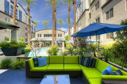 Phoenix Luxury Apartments - Level At Sixteenth - Outdoor Lounge With Sun Umbrella, View Of Pool, And Green Patio Sectional Couch