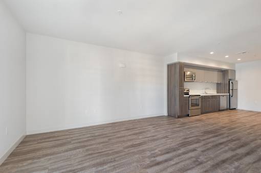 A kitchen area with a wooden floor and a white wall at Wilshire Valencia Apartment, Los Angeles, California